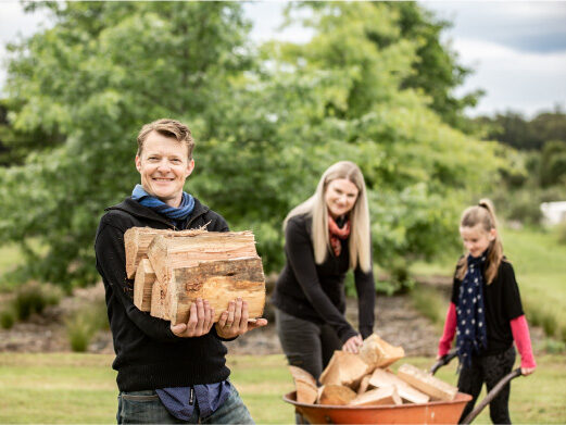 Family stacking seasoned firewood outdoors sustainable firewood delivery for Upper Hutt homes